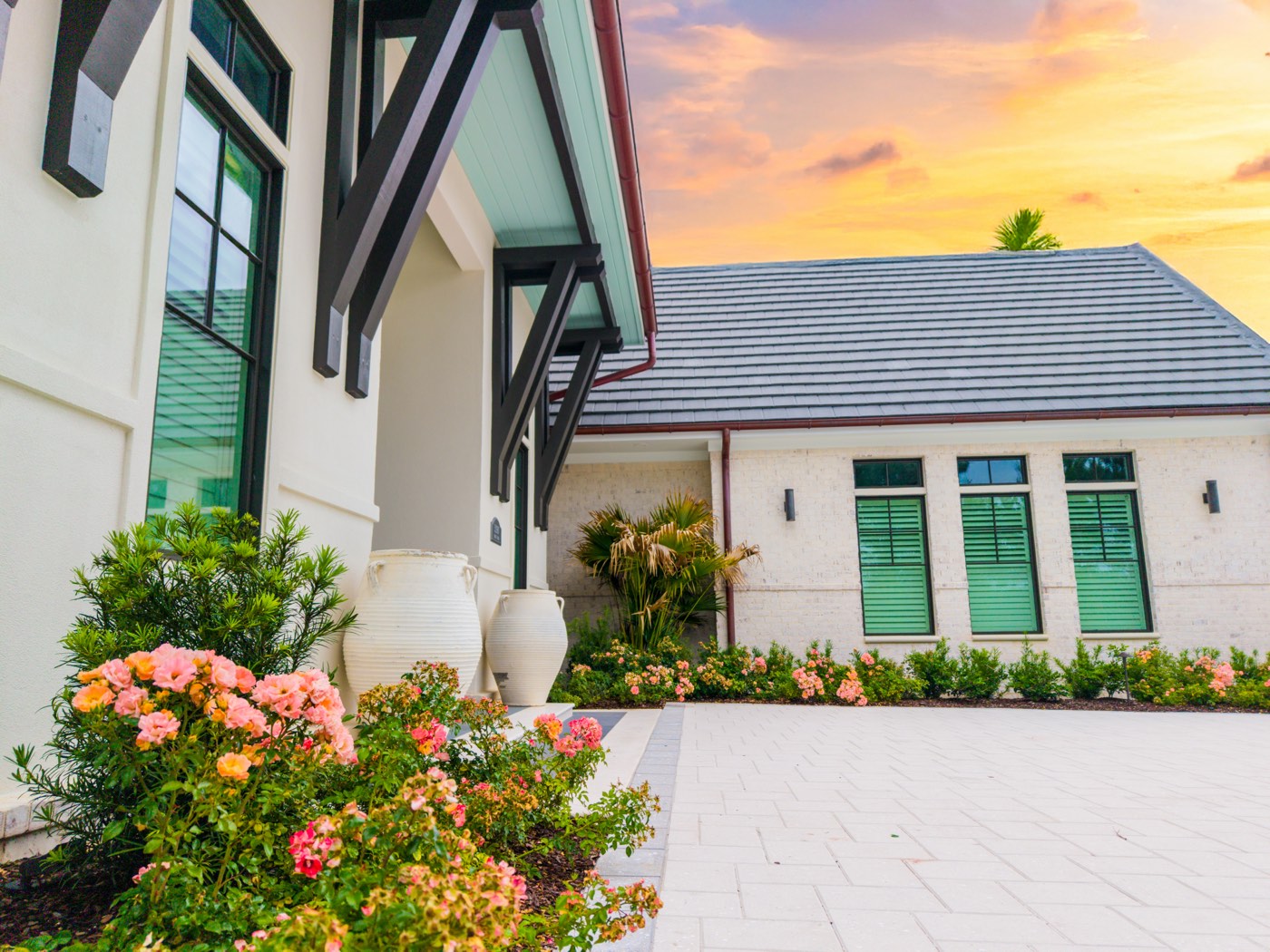 Home entryway with flowering shrubs under a vivid sunset sky, Ono Island