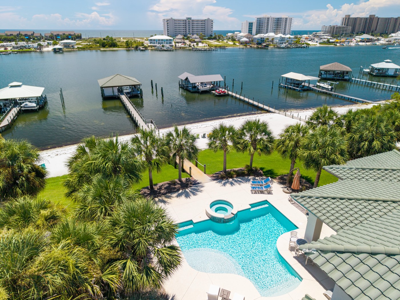 Aerial view of a pool, private beach, and boat docks along the bay, Ono Island