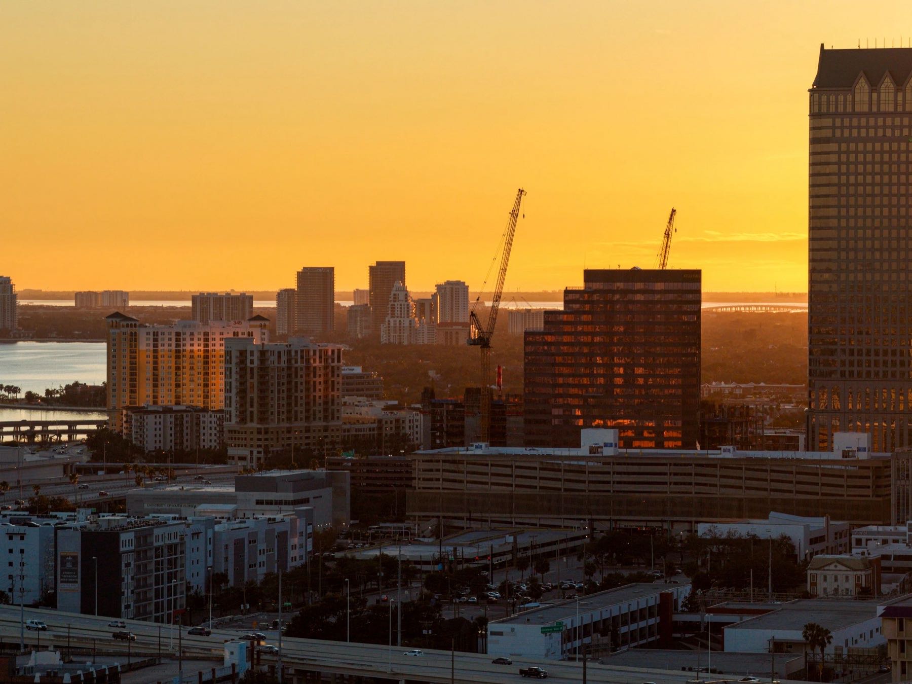 City skyline at sunset with a construction crane