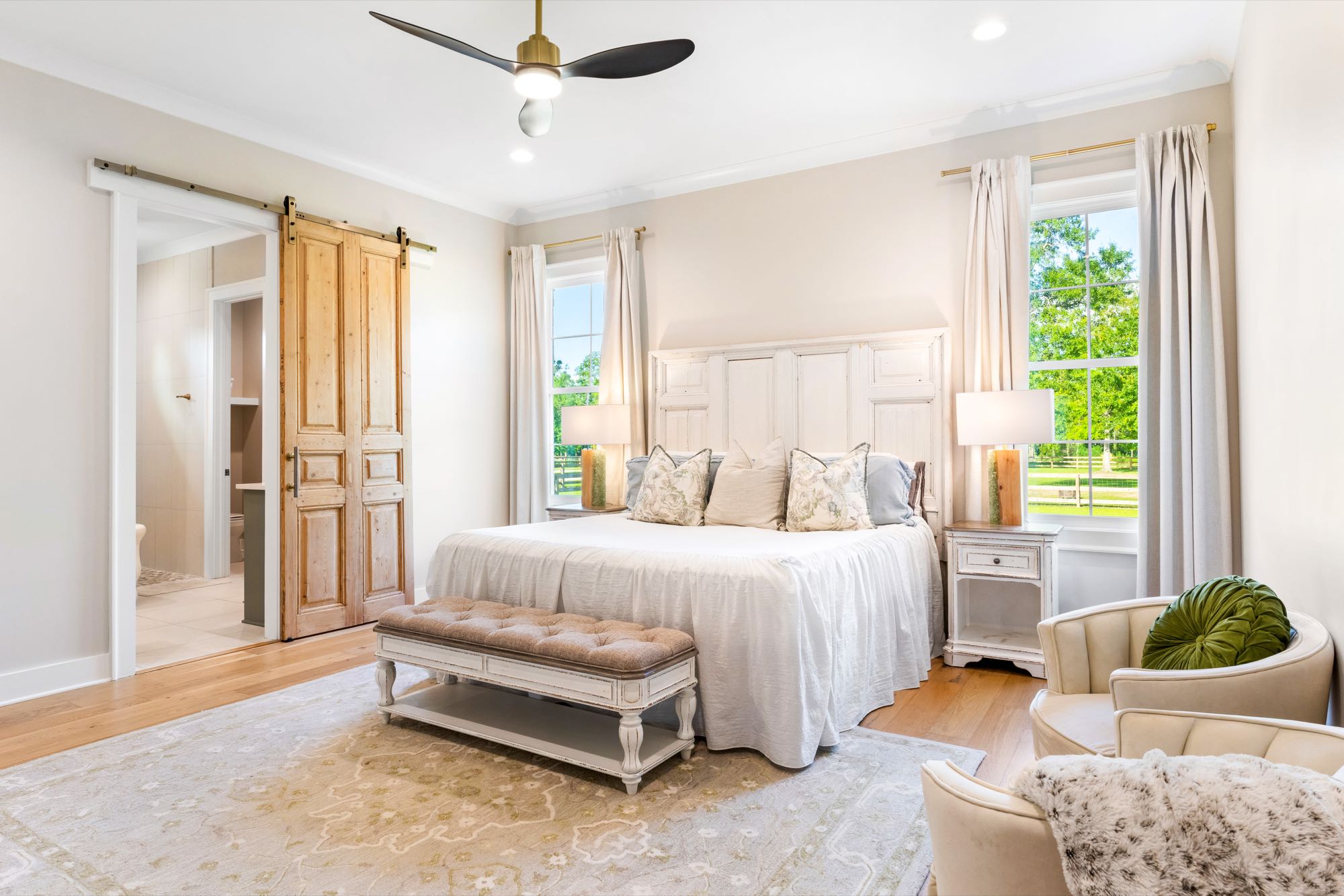 Bright primary bedroom with wood floors and natural light