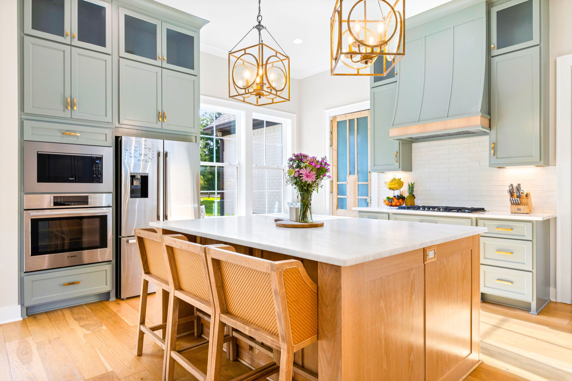 Bright open kitchen with sage cabinetry and wood beam ceiling