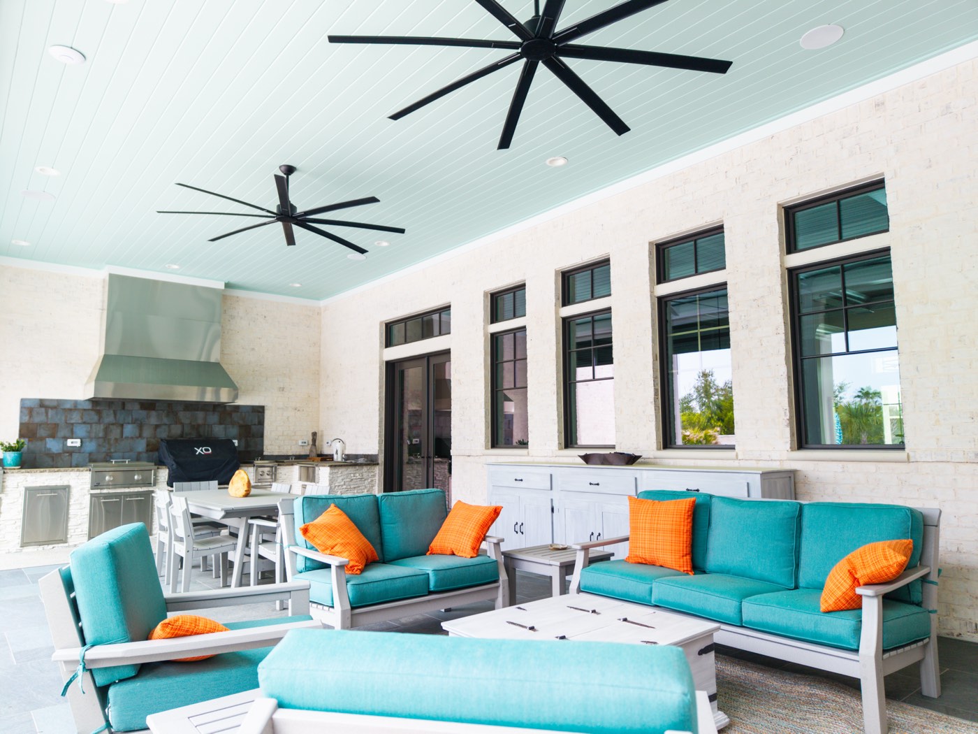 Covered outdoor living and kitchen space with teal furniture, Ono Island