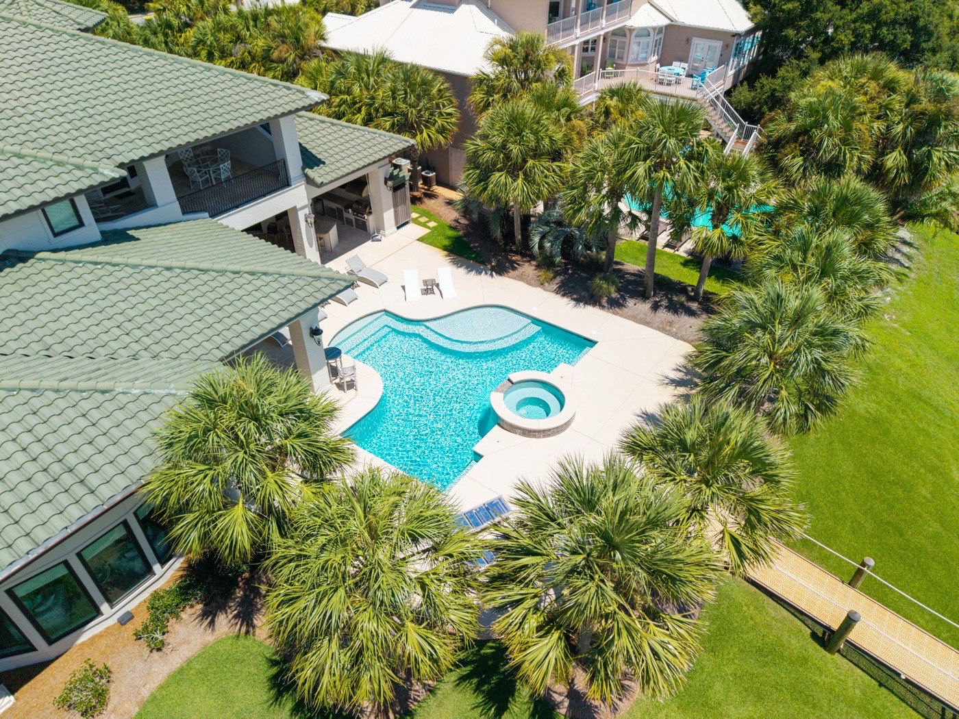 Freeform pool and spa framed by palm trees, aerial view, Ono Island