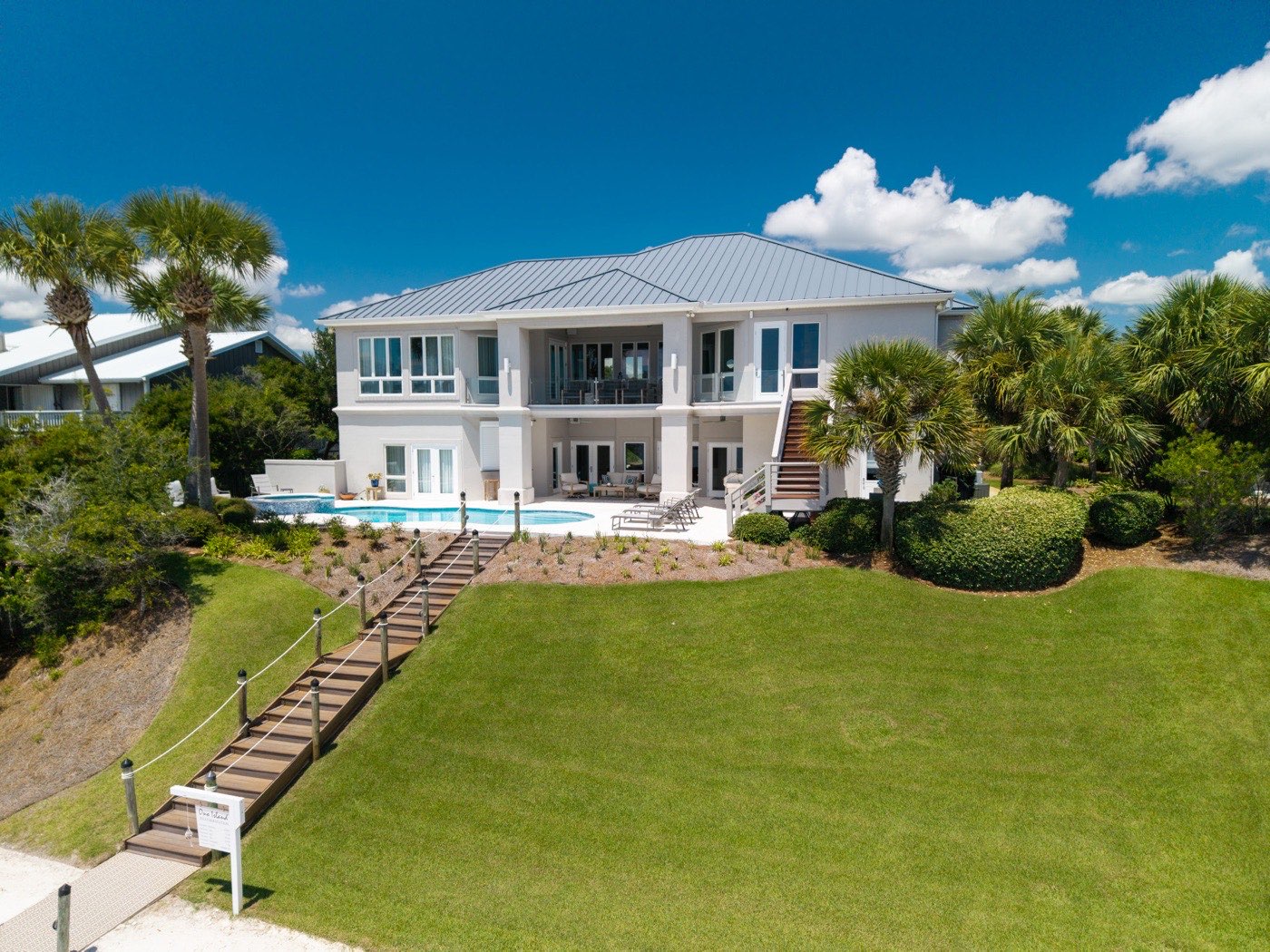 Coastal home with pool and a boardwalk staircase leading down to the lawn, Ono Island