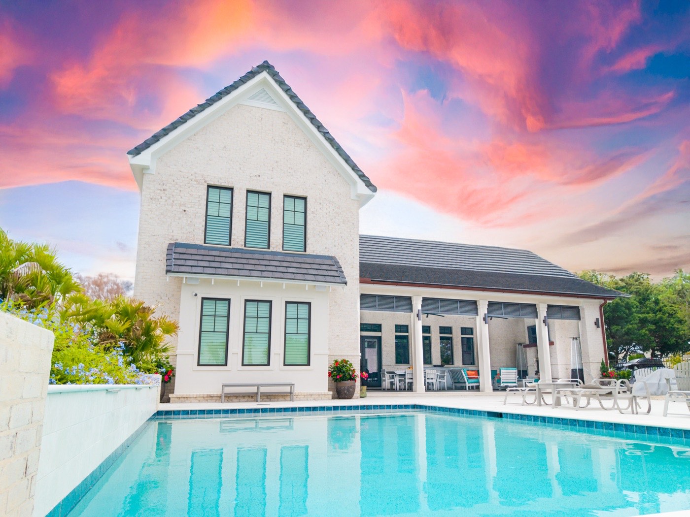 Coastal home pool under a vivid pink and purple sunset sky, Ono Island