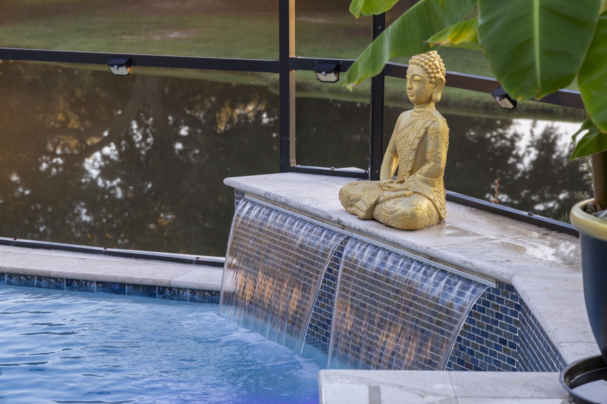 Courtyard fountain with a gold statue, framed by potted plants