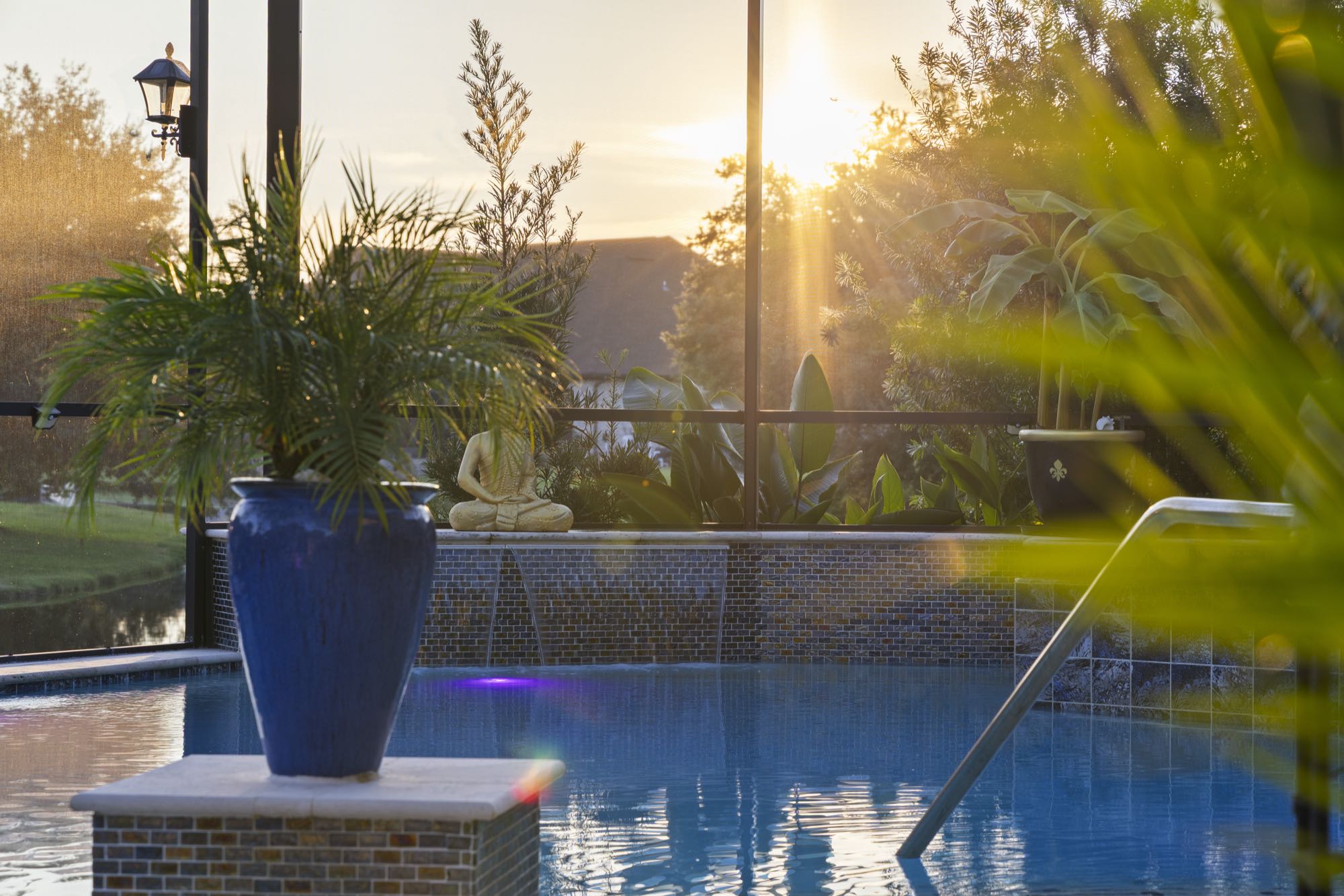 Screened-in pool and spa lanai at dusk with string lighting