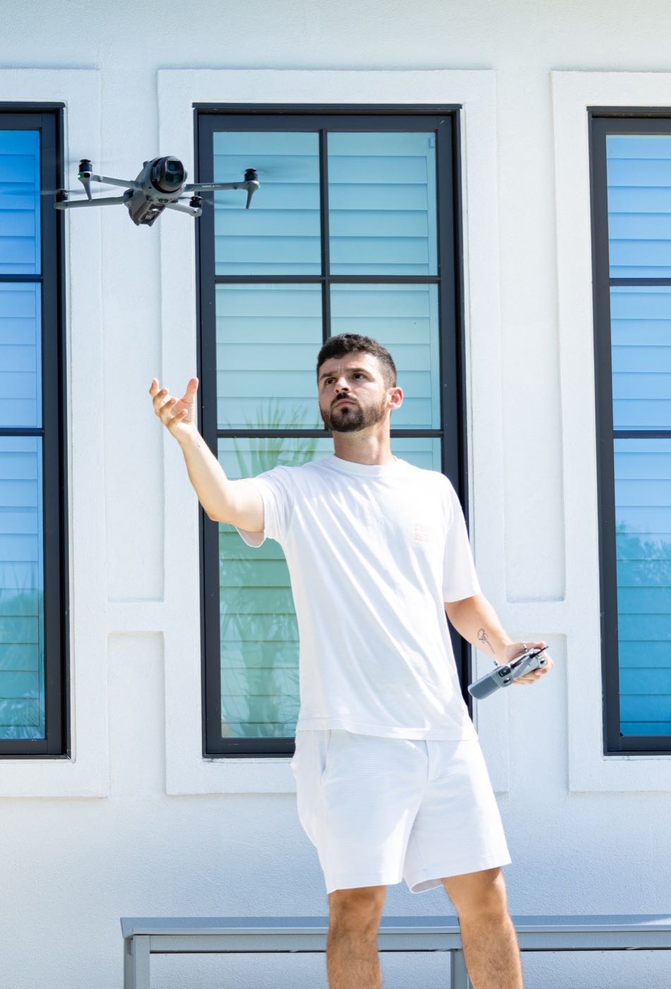 Salt Air Media founder launching a drone in front of a coastal home