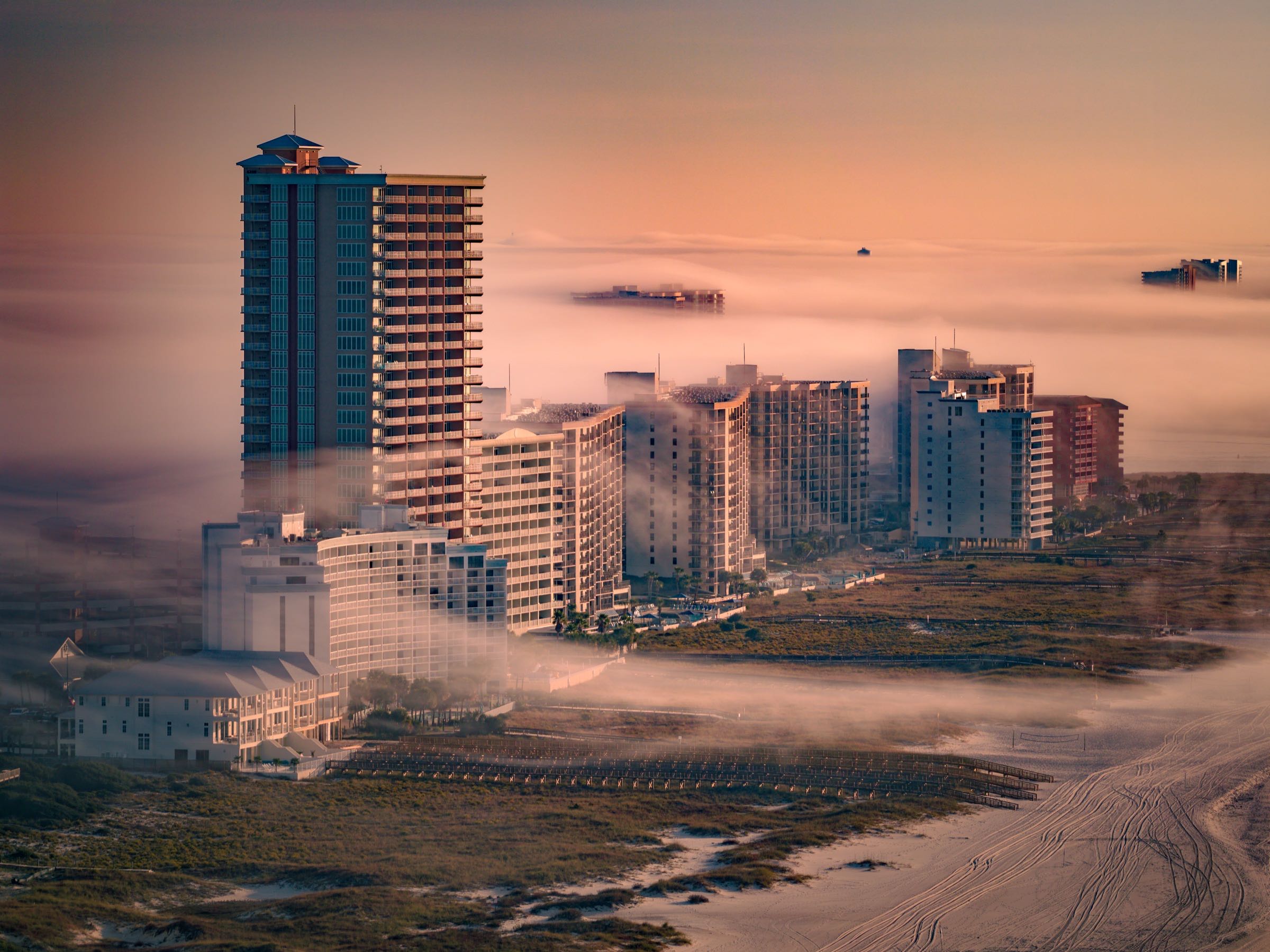 Sea fog rolling over condo towers at dusk, Gulf Shores